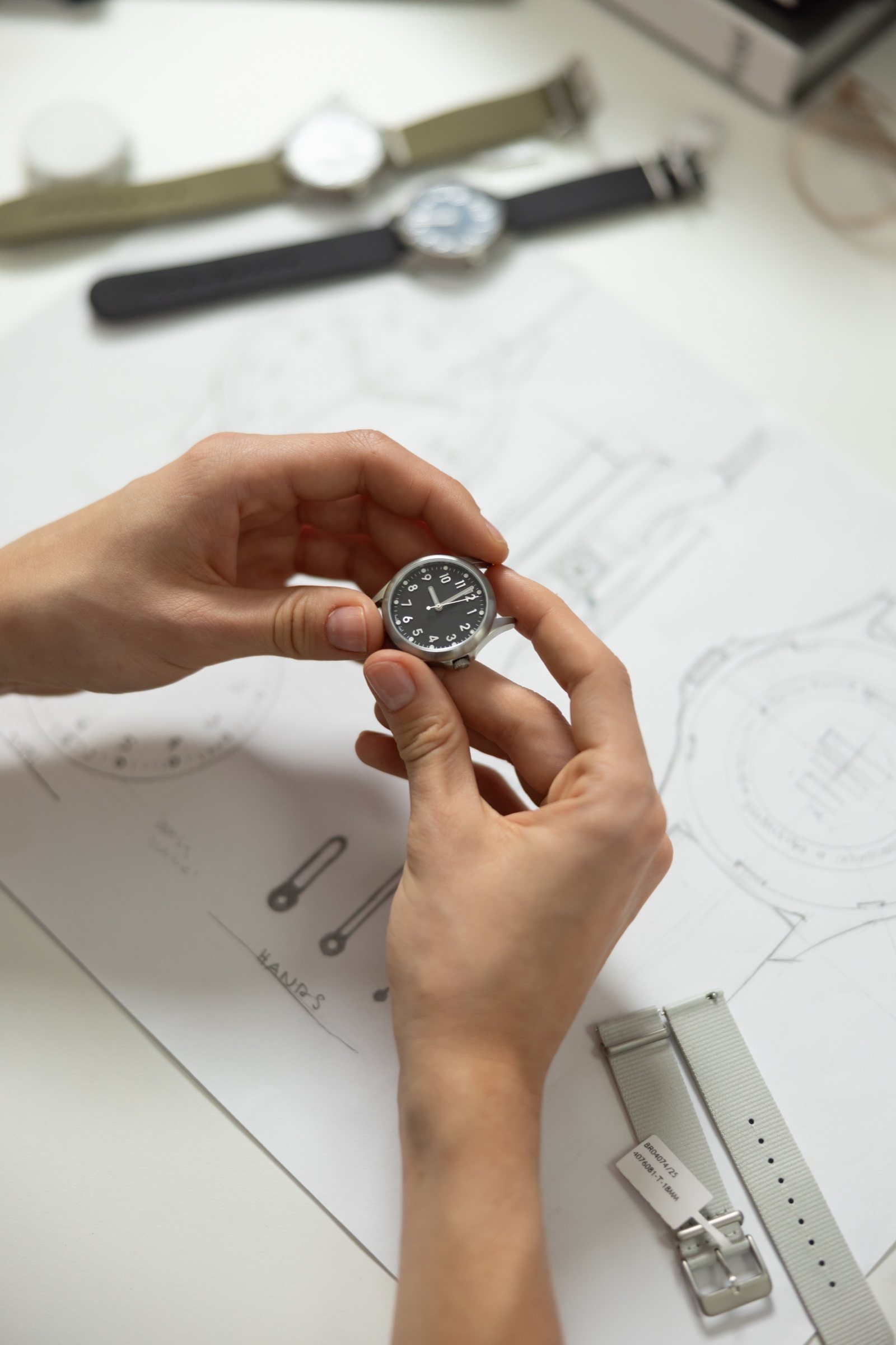 Hands holding a Mudita Radiant over its technical drawings